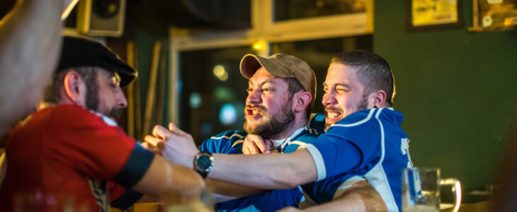 Angry soccer fans of two rival teams fighting in sports bar