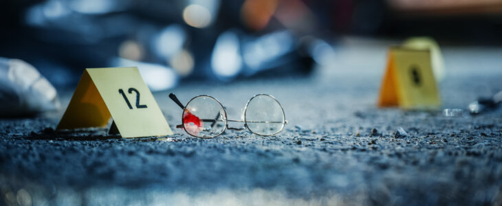 A Ground Level Shot of Evidence on a Crime Scene Investigated by Forensics. A Photo of Numbered Marker Next to Bloody Glasses Potentially Belonging and Left Behind by the Killer