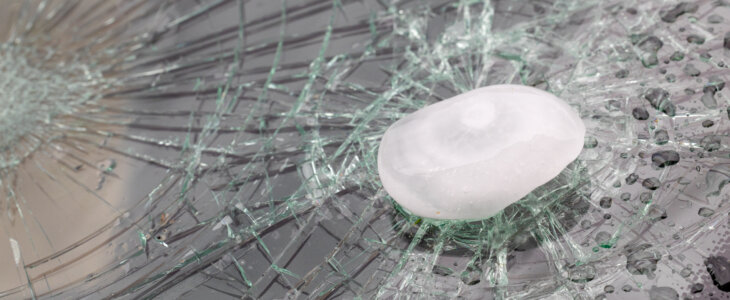 Close-up of damaged car windshield by hail