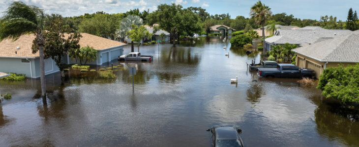 Hurricane rainfall flooded road. Drowned car on city street in Florida residential area. Consequences of hurricane natural disaster.