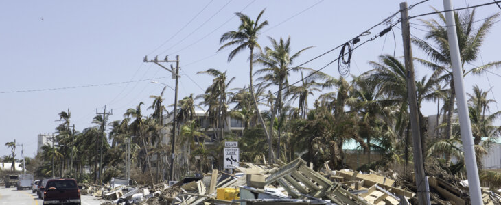 There are mounds of trash and debris placed along side of a roadway after a hurricane hit the Florida Keys. Trees have fallen on power lines causing outages. Shot taken with Canon 5D Mark lV