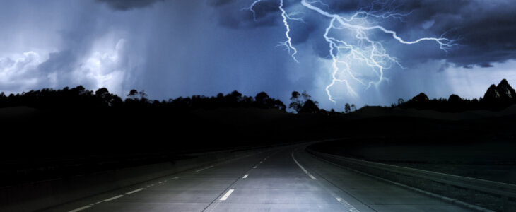 dark night road through forest and mountains, rain and storm with lightning